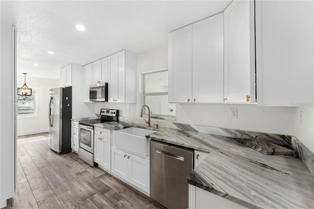 1816 W Lake Parker Dr, Lakeland, FL 33805 - kitchen with appliances with stainless steel finishes, a sink, white cabinets, light stone countertops, and recessed lighting