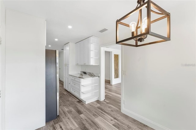 1816 W Lake Parker Dr, Lakeland, FL 33805 - kitchen with open shelves, white cabinetry, light wood finished floors, a chandelier, and recessed lighting