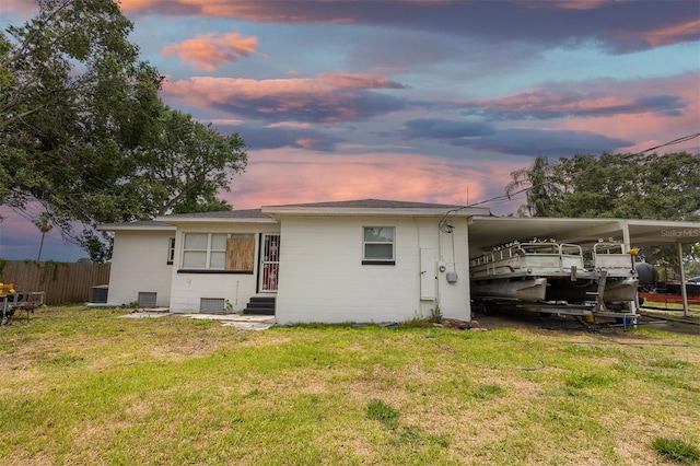 1816 W Lake Parker Dr, Lakeland, FL 33805 - back of property at dusk featuring entry steps, an attached carport, and central air condition unit