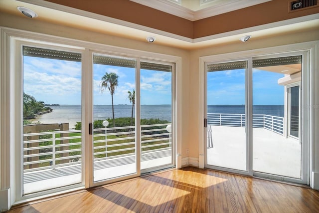812 Point Seaside Dr, Crystal Beach, FL 34681 - spare room featuring a water view, wood finished floors, and ornamental molding
