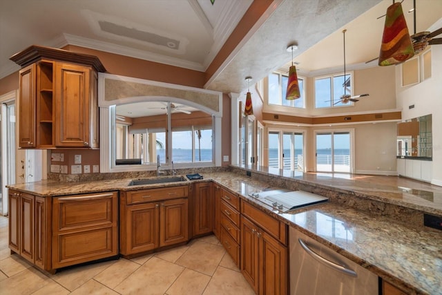 812 Point Seaside Dr, Crystal Beach, FL 34681 - kitchen with ceiling fan, stovetop, brown cabinets, ornamental molding, and a towering ceiling