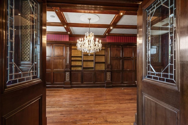 812 Point Seaside Dr, Crystal Beach, FL 34681 - entryway featuring a chandelier, coffered ceiling, wood finished floors, beam ceiling, and a decorative wall