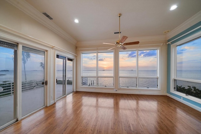 812 Point Seaside Dr, Crystal Beach, FL 34681 - unfurnished sunroom featuring a water view, crown molding, wood finished floors, recessed lighting, and baseboards