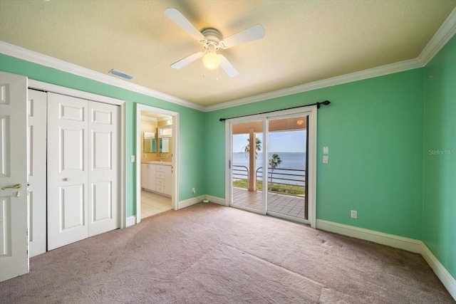 812 Point Seaside Dr, Crystal Beach, FL 34681 - unfurnished bedroom with access to exterior, carpet floors, ornamental molding, baseboards, and a ceiling fan