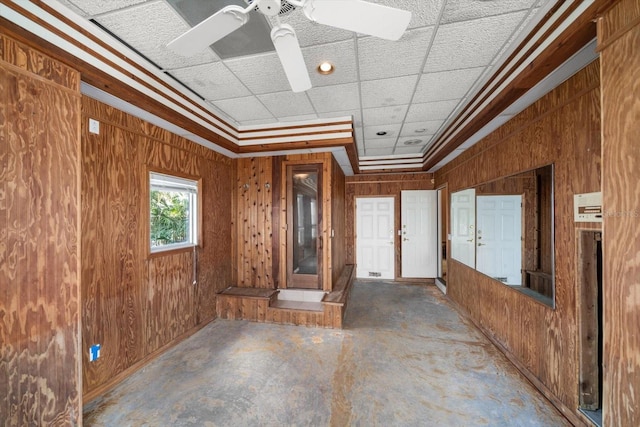 812 Point Seaside Dr, Crystal Beach, FL 34681 - empty room with wooden walls, unfinished concrete flooring, crown molding, and ceiling fan