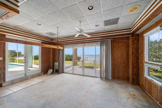 812 Point Seaside Dr, Crystal Beach, FL 34681 - spare room featuring a water view, unfinished concrete floors, ceiling fan, and a drop ceiling