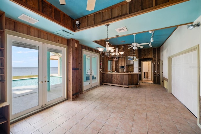 812 Point Seaside Dr, Crystal Beach, FL 34681 - kitchen featuring ceiling fan, wooden walls, a chandelier, french doors, and a water view