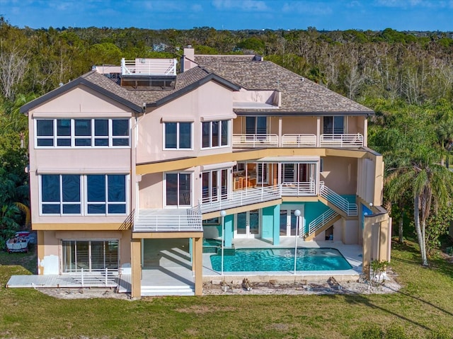 812 Point Seaside Dr, Crystal Beach, FL 34681 - rear view of property with a balcony, stucco siding, a lawn, a patio, and an outdoor pool