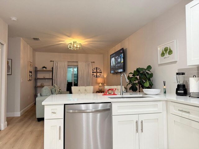 6977 Hawksbury St, Englewood, FL 34224 - kitchen featuring dishwasher, a peninsula, a sink, open floor plan, and light wood-style flooring