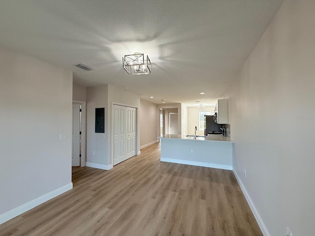 6977 Hawksbury St, Englewood, FL 34224 - unfurnished living room with light wood finished floors, a sink, baseboards, and recessed lighting