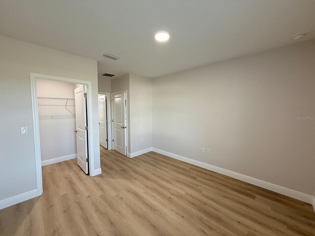 6977 Hawksbury St, Englewood, FL 34224 - unfurnished bedroom featuring light wood finished floors, baseboards, a spacious closet, and a closet