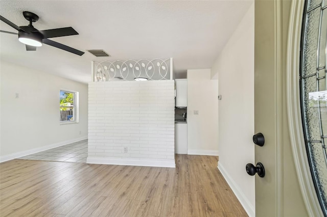 3818 Grove St S, Saint Petersburg, FL 33705 - empty room featuring light wood finished floors, a ceiling fan, and baseboards