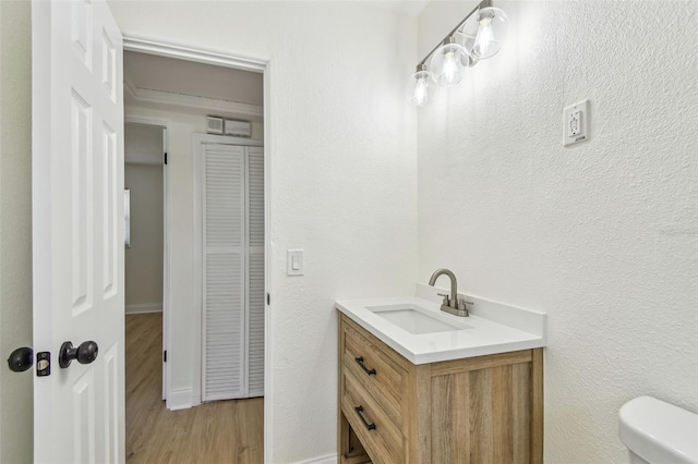 3818 Grove St S, Saint Petersburg, FL 33705 - bathroom featuring toilet, vanity, wood finished floors, and baseboards