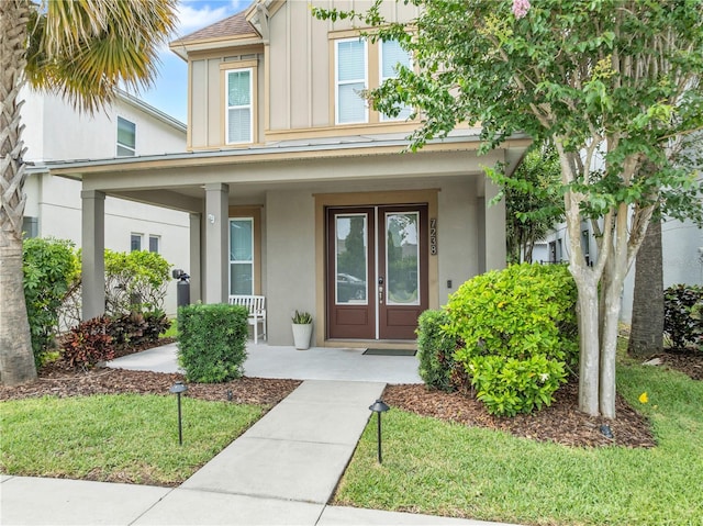 7238 Milestone Dr, Apollo Beach, FL 33572 - view of front of property featuring board and batten siding, covered porch, and stucco siding