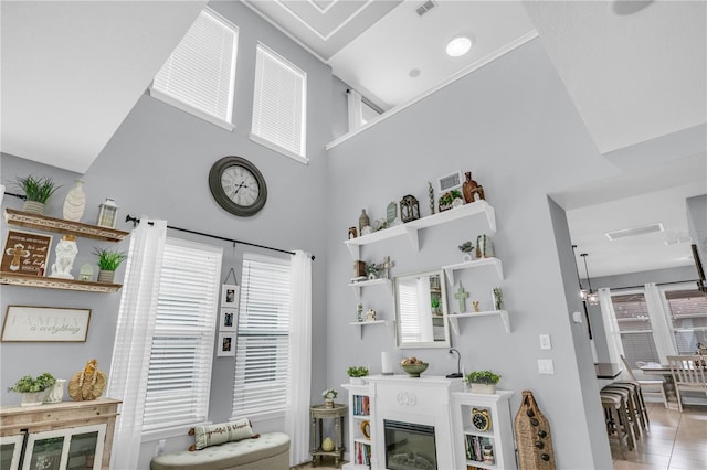 7238 Milestone Dr, Apollo Beach, FL 33572 - living room with a high ceiling, a glass covered fireplace, and tile patterned floors