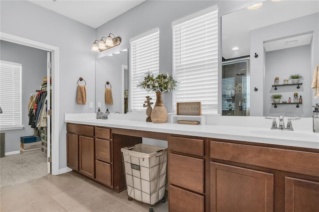 7238 Milestone Dr, Apollo Beach, FL 33572 - bathroom featuring double vanity, a shower stall, tile patterned floors, and a walk in closet