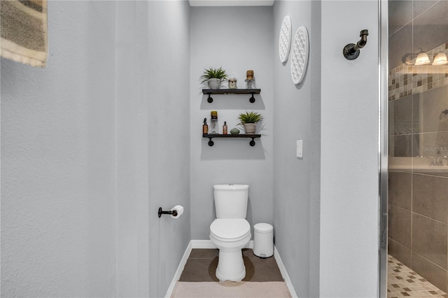 7238 Milestone Dr, Apollo Beach, FL 33572 - bathroom with toilet, a tile shower, tile patterned floors, and baseboards