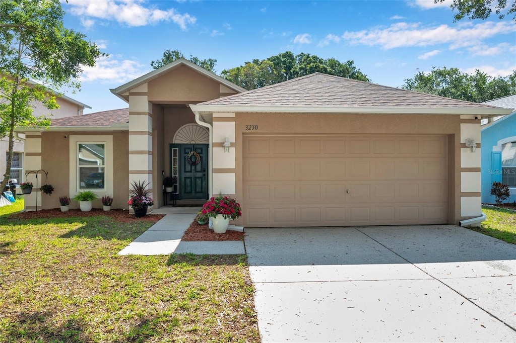 3230 Bellericay Ln, Land O Lakes, FL 34638 - ranch-style home with stucco siding, a garage, concrete driveway, roof with shingles, and a front yard