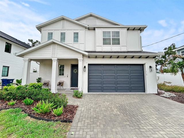718 W Kentucky Ave, Tampa, FL 33603 - view of front of house featuring an attached garage, stucco siding, decorative driveway, and covered porch