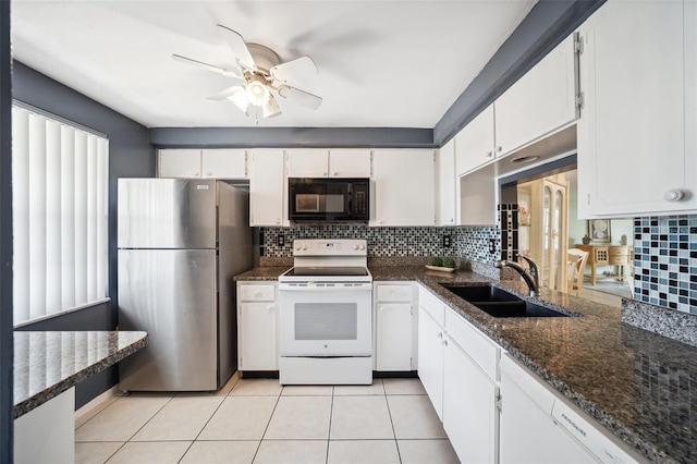 4229 Glissade Dr, New Port Richey, FL 34652 - kitchen featuring white electric range oven, freestanding refrigerator, black microwave, a sink, and tasteful backsplash