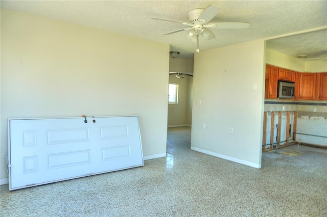 14501 N Bayshore Dr, Madeira Beach, FL 33708 - spare room featuring a ceiling fan, baseboards, and a textured ceiling