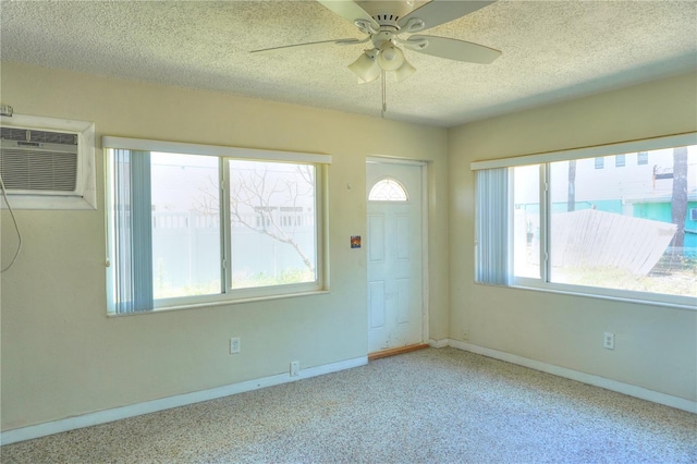 14501 N Bayshore Dr, Madeira Beach, FL 33708 - carpeted foyer entrance with an AC wall unit, a ceiling fan, a textured ceiling, and baseboards