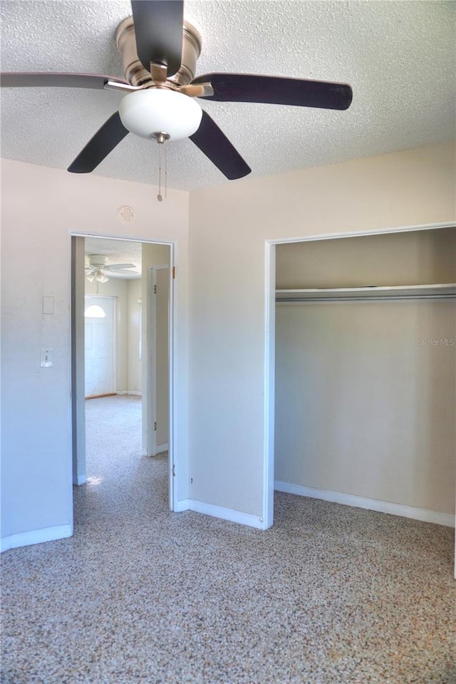 14501 N Bayshore Dr, Madeira Beach, FL 33708 - unfurnished bedroom featuring baseboards, a textured ceiling, ceiling fan, and a closet