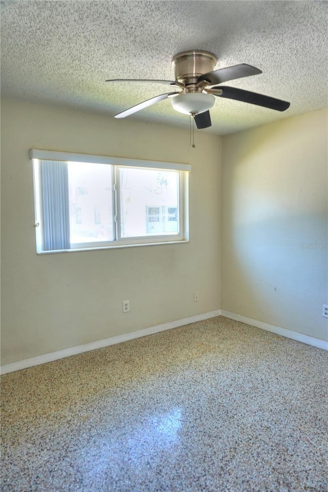 14501 N Bayshore Dr, Madeira Beach, FL 33708 - empty room with ceiling fan, a textured ceiling, and baseboards
