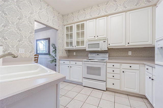 350 2nd St N Unit 1, Saint Petersburg, FL 33701 - kitchen featuring white appliances, a sink, light tile patterned flooring, wallpapered walls, and light countertops