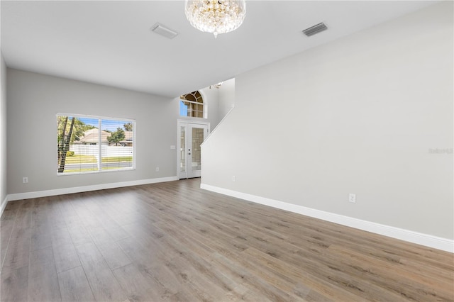 4852 Trinidad Dr, Land O Lakes, FL 34639 - unfurnished living room featuring a chandelier, baseboards, and wood finished floors