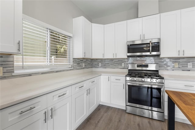 4852 Trinidad Dr, Land O Lakes, FL 34639 - kitchen with appliances with stainless steel finishes, tasteful backsplash, white cabinetry, and dark wood finished floors