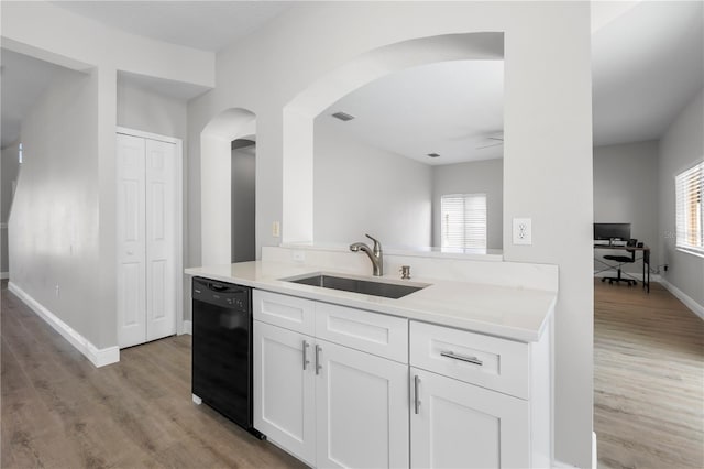 4852 Trinidad Dr, Land O Lakes, FL 34639 - kitchen with black dishwasher, a sink, arched walkways, and light wood-type flooring