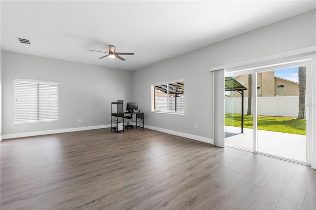 4852 Trinidad Dr, Land O Lakes, FL 34639 - empty room with a desk, wood finished floors, a ceiling fan, and baseboards