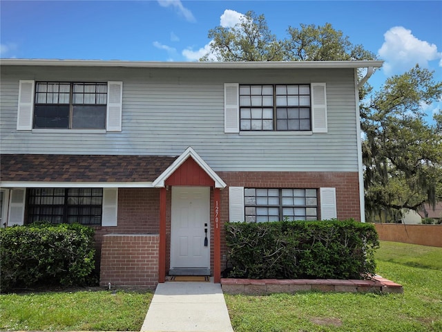 12701 N 57th St -, Unit Tampa, FL 33617 - view of front of house featuring brick siding and a front yard