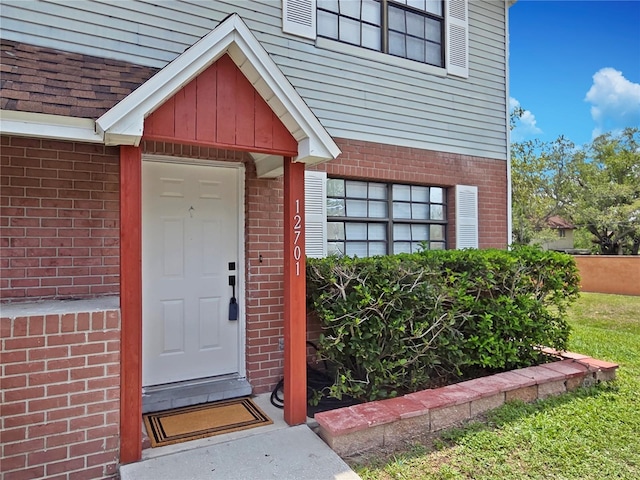 12701 N 57th St -, Unit Tampa, FL 33617 - doorway to property featuring brick siding