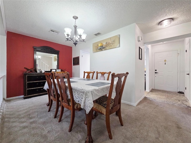 12701 N 57th St -, Unit Tampa, FL 33617 - dining space featuring a chandelier, light carpet, a textured ceiling, and baseboards