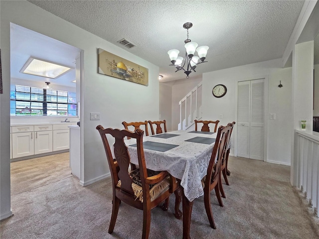 12701 N 57th St -, Unit Tampa, FL 33617 - dining area featuring a chandelier, light carpet, a textured ceiling, and baseboards
