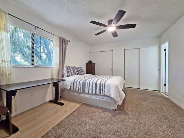 12701 N 57th St -, Unit Tampa, FL 33617 - bedroom featuring two closets, a textured ceiling, wood finished floors, baseboards, and ceiling fan