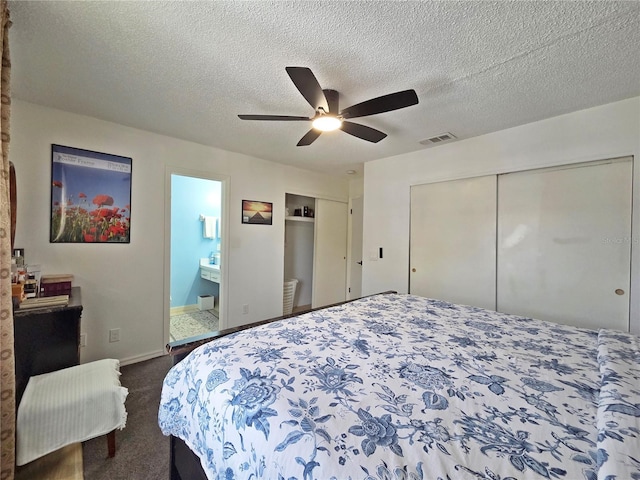 12701 N 57th St -, Unit Tampa, FL 33617 - bedroom with dark colored carpet, connected bathroom, a ceiling fan, baseboards, and a textured ceiling