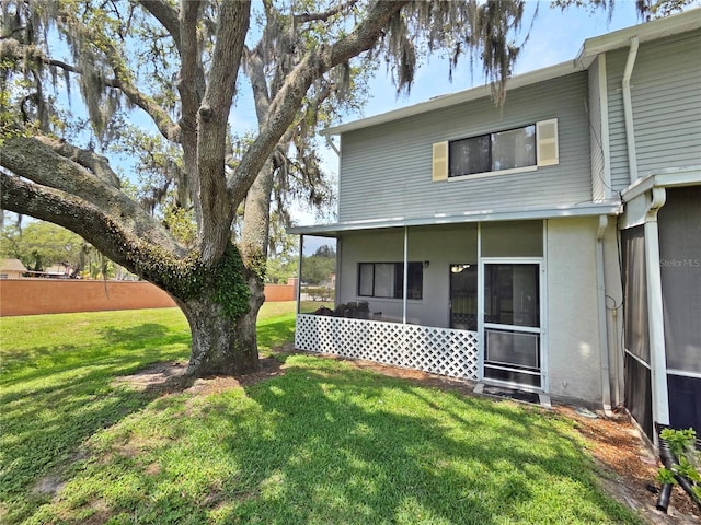 12701 N 57th St -, Unit Tampa, FL 33617 - back of property featuring a sunroom and a lawn