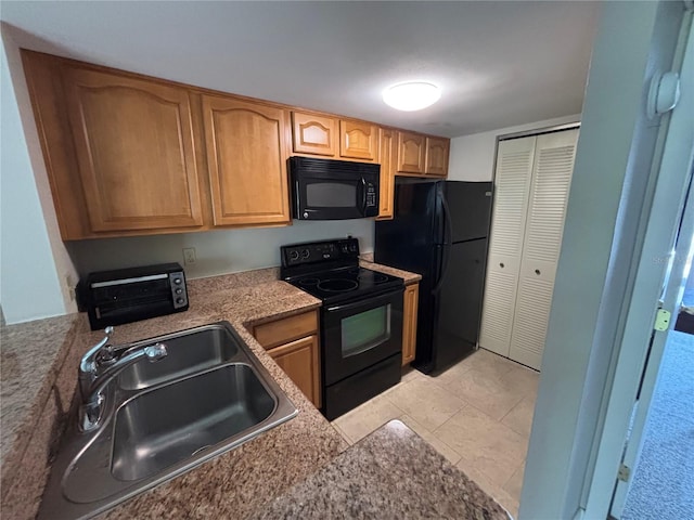 3814 N Lake Dr Unit 65, Tampa, FL 33614 - kitchen featuring black appliances, a sink, and light tile patterned floors