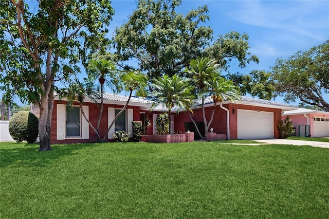 2138 Viola Dr, Clearwater, FL 33764 - ranch-style house with a garage, a front lawn, driveway, and brick siding