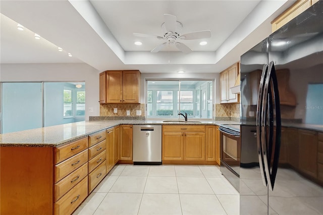 2138 Viola Dr, Clearwater, FL 33764 - kitchen featuring black appliances, a sink, light stone counters, a ceiling fan, and backsplash