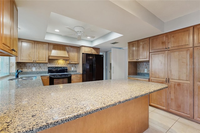 2138 Viola Dr, Clearwater, FL 33764 - kitchen with black appliances, custom exhaust hood, a sink, a raised ceiling, and light stone counters