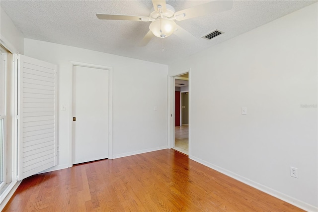 2138 Viola Dr, Clearwater, FL 33764 - unfurnished bedroom featuring wood finished floors, a textured ceiling, baseboards, a ceiling fan, and a closet