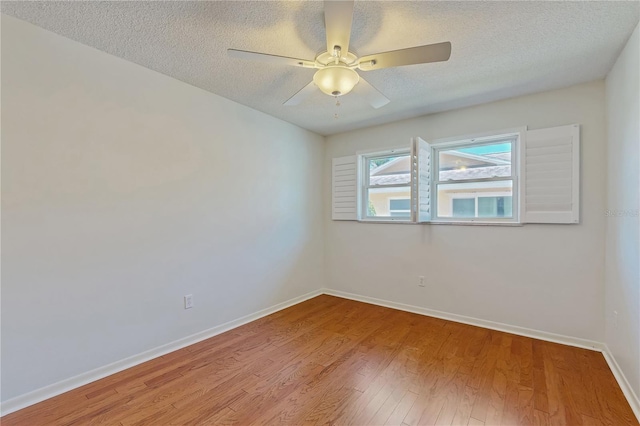 2138 Viola Dr, Clearwater, FL 33764 - empty room featuring wood finished floors, a ceiling fan, a textured ceiling, and baseboards