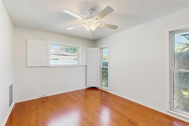 2138 Viola Dr, Clearwater, FL 33764 - empty room featuring a textured ceiling, wood finished floors, baseboards, and ceiling fan