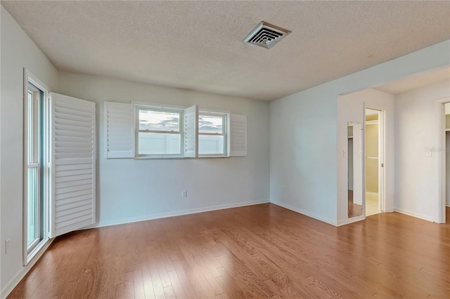 2138 Viola Dr, Clearwater, FL 33764 - spare room with wood finished floors, a textured ceiling, and baseboards