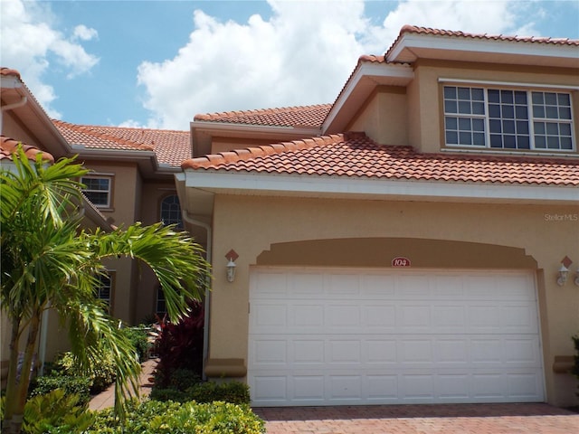 13860 Avon Park Cir Unit 104, Fort Myers, FL 33912 - view of front of house featuring stucco siding, decorative driveway, and a tiled roof