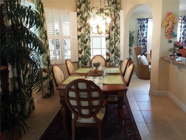 13860 Avon Park Cir Unit 104, Fort Myers, FL 33912 - dining area with baseboards, a chandelier, tile patterned floors, and arched walkways